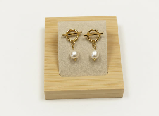 Boucles d'oreilles à puce en acier inoxydable composées d'un anneau et barre avec une perle d'eau douce pendante.