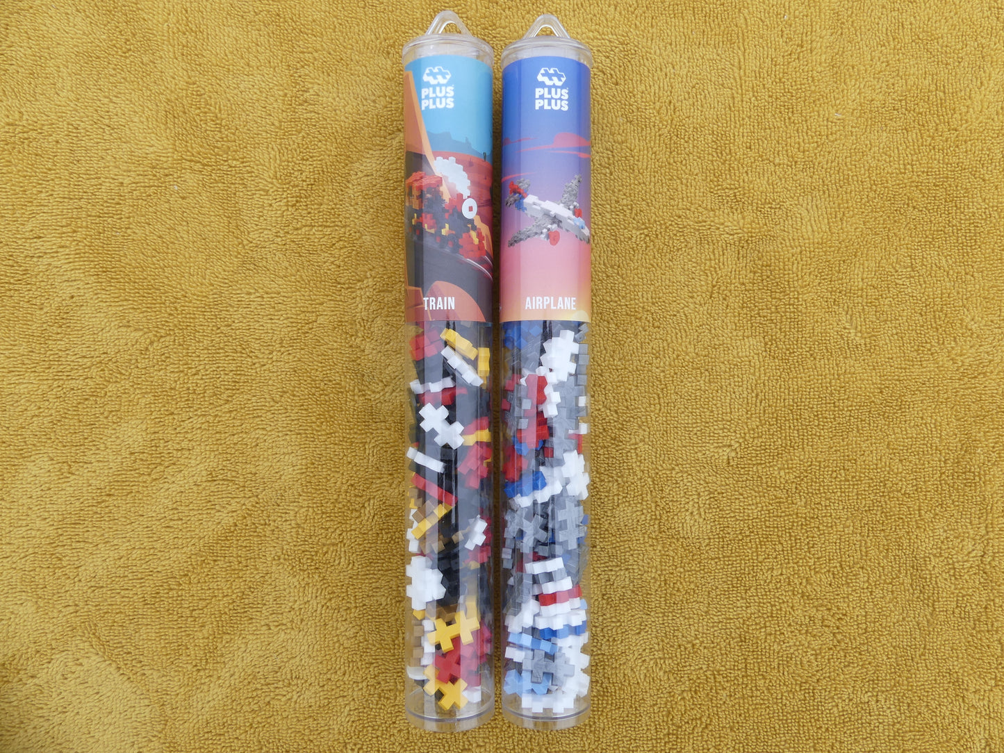 Lot de deux tubes de puzzle: un tube avion et un tube train.