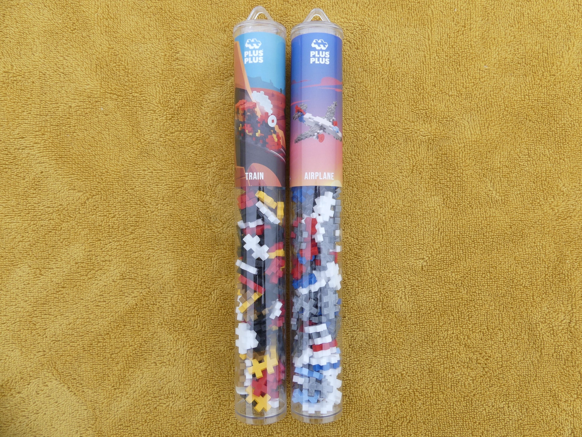 Lot de deux tubes de puzzle: un tube avion et un tube train.